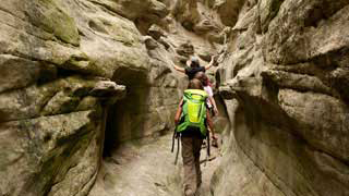 Man on a bike cycling through a canyon